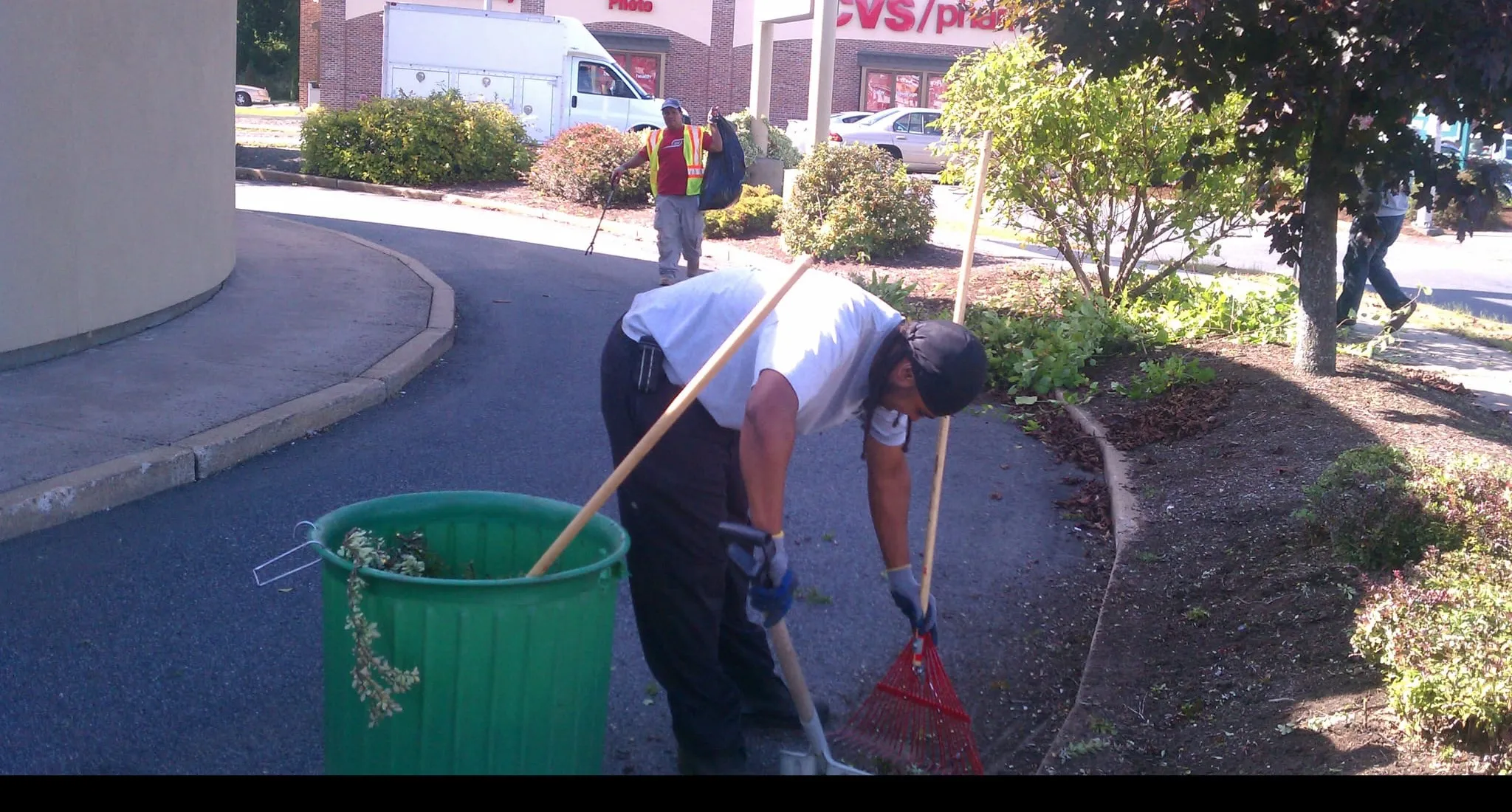 Crew raking and cleaning up landscape beds at a commercial property in Massachusetts