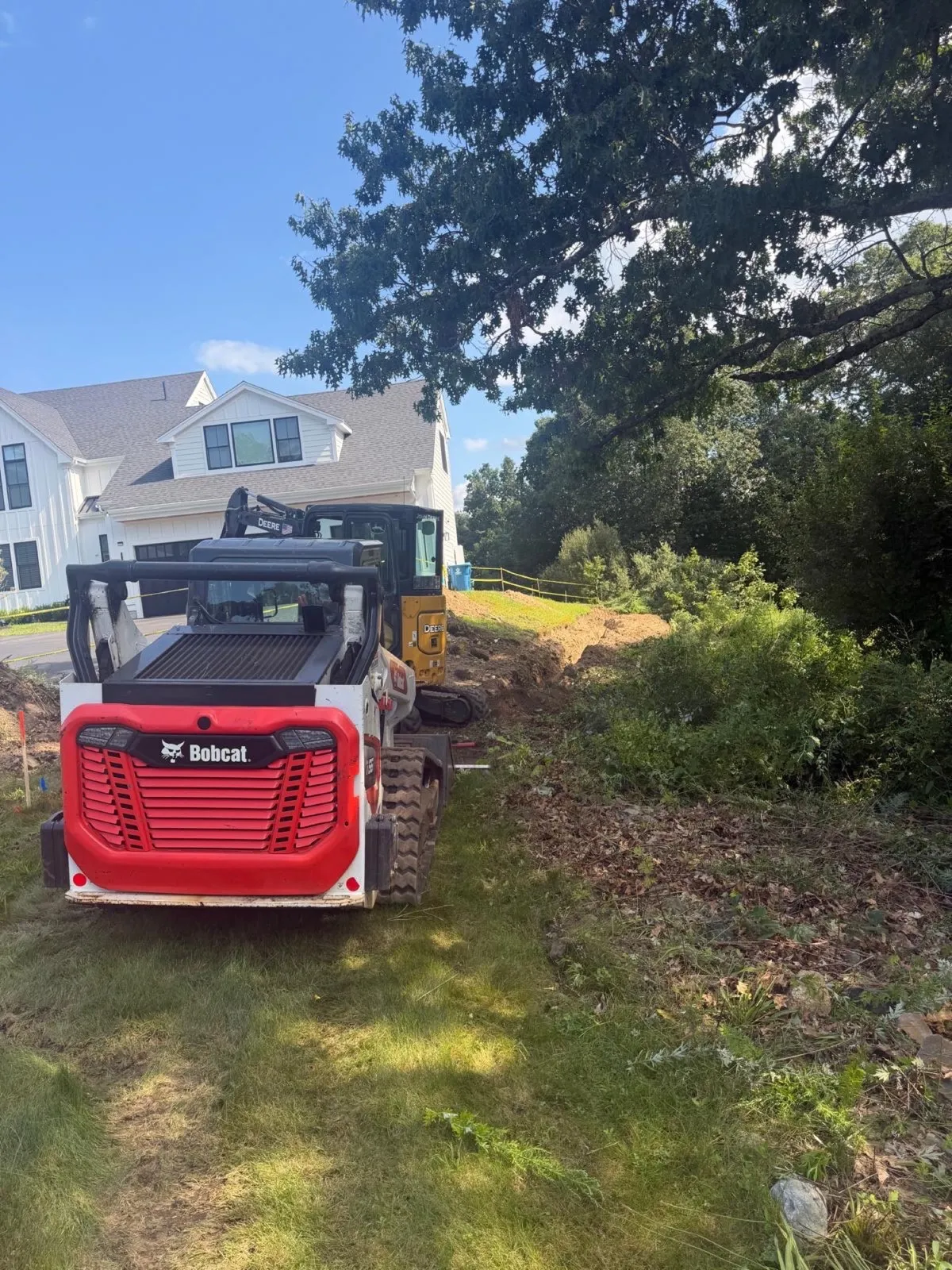 Skid steer preparing a site during excavation in Massachusetts