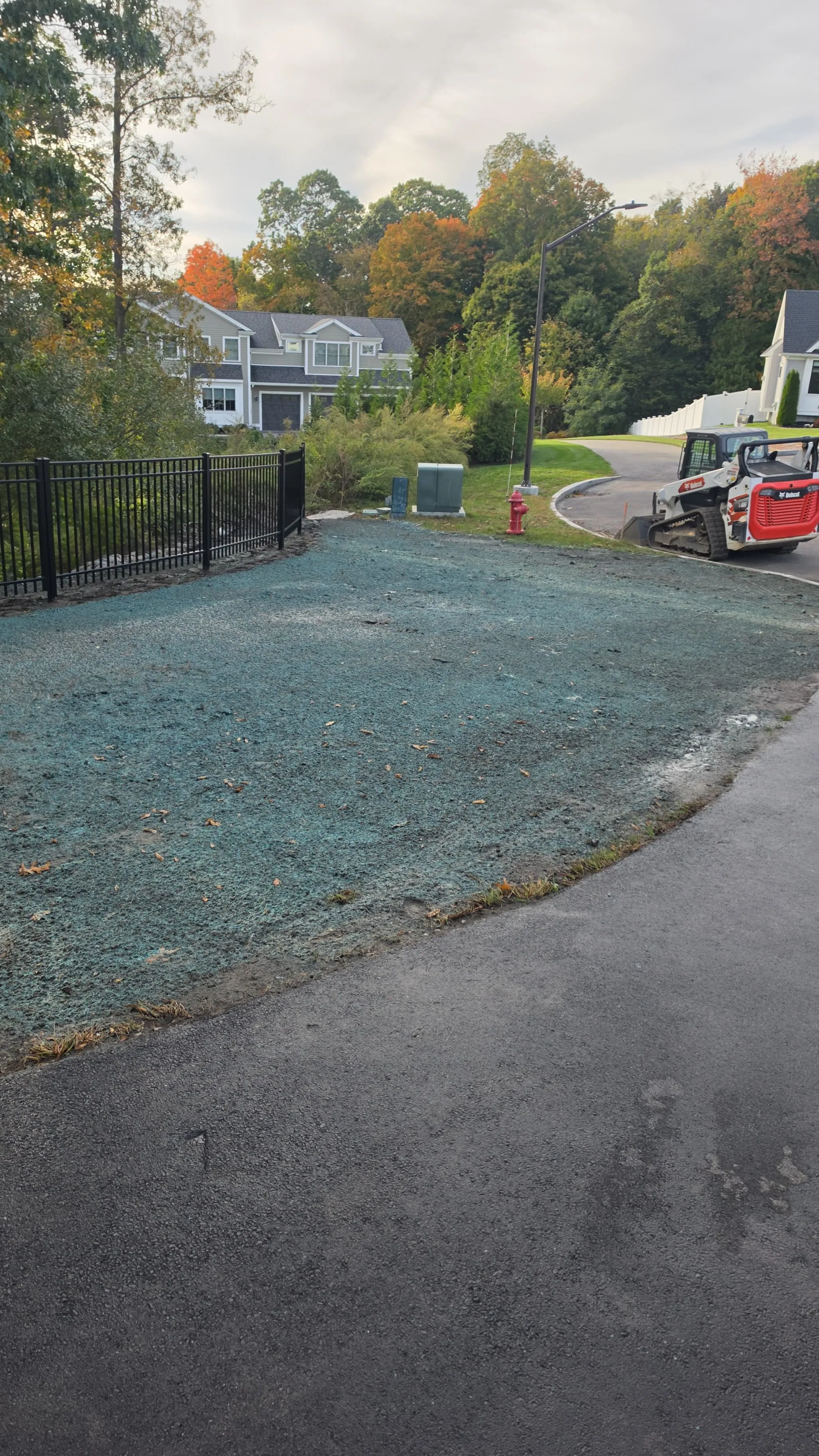 Freshly hydroseeded lawn along a residential driveway in Massachusetts
