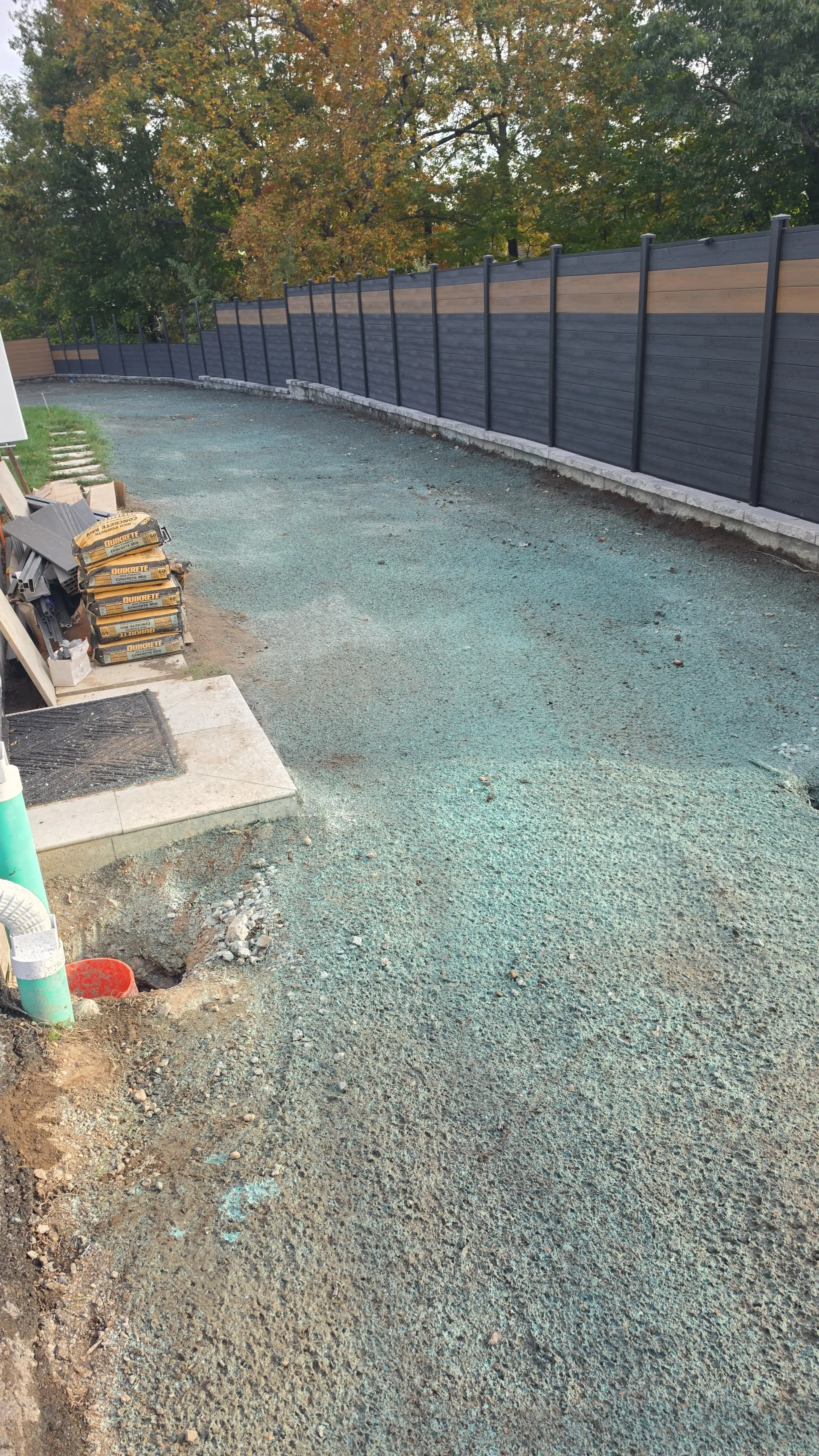 Hydroseeded side yard along a new composite privacy fence in Massachusetts