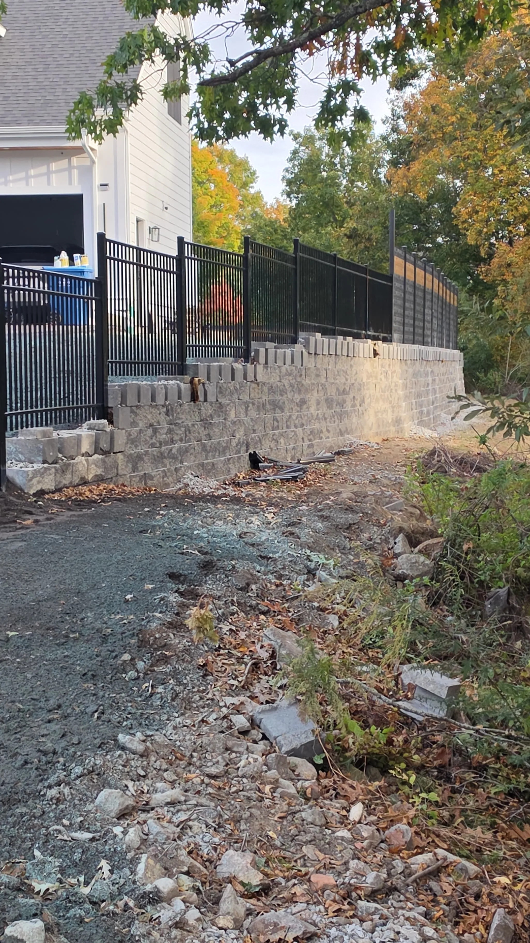 Cap stones being set on a segmental retaining wall in Massachusetts