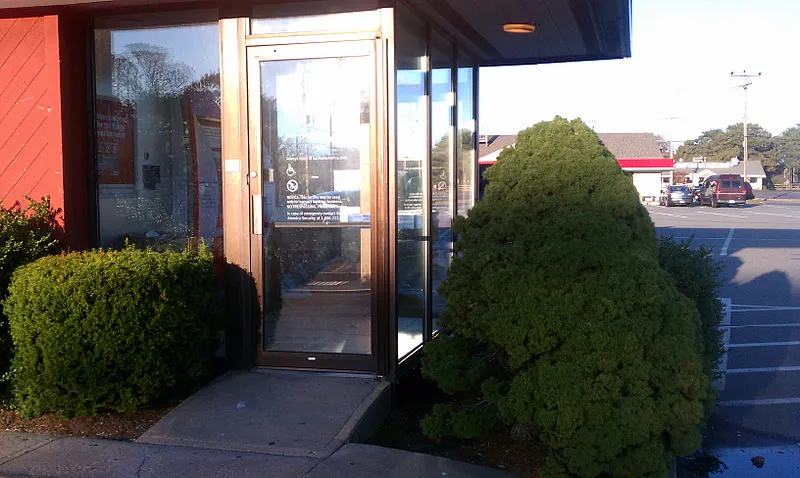 Neatly trimmed shrubs framing a commercial building entrance in Massachusetts